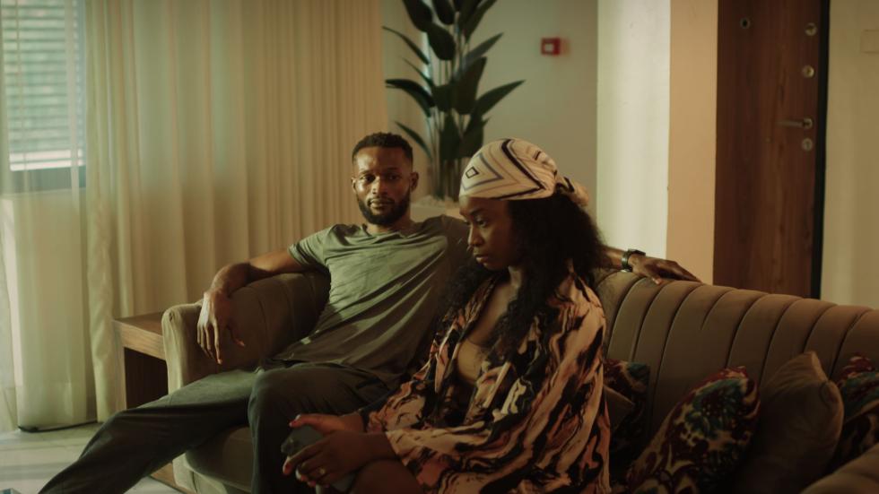 Nikiya and Luc sit on a couch