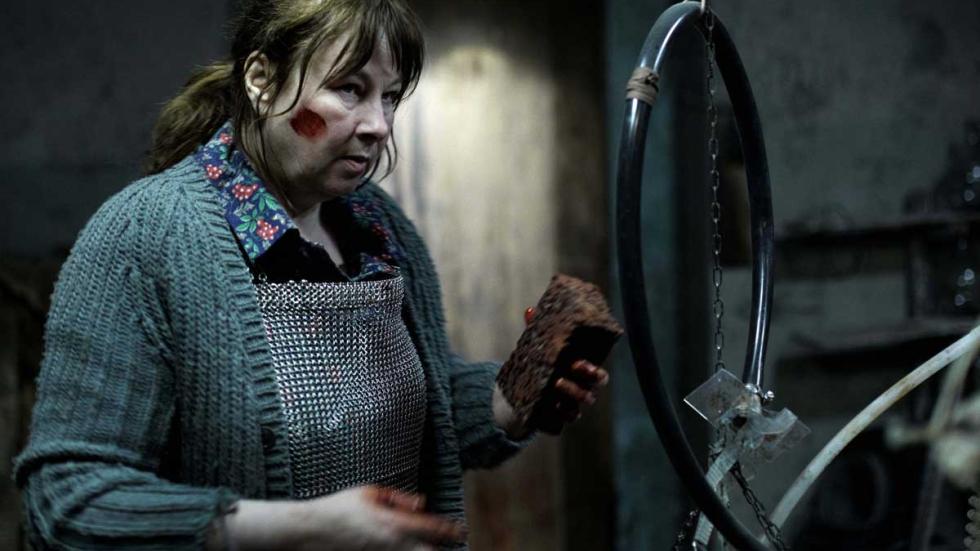 The Pack older woman holds a brick