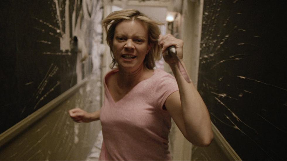 The Visitant woman runs with a knife down a hall