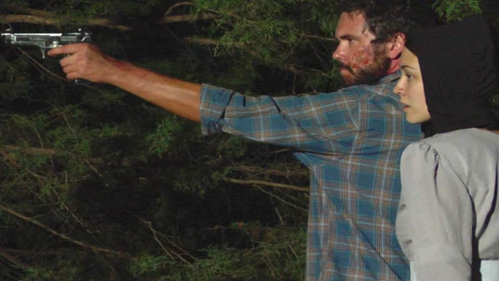 The Season man points pistol at something with a women net to hiim