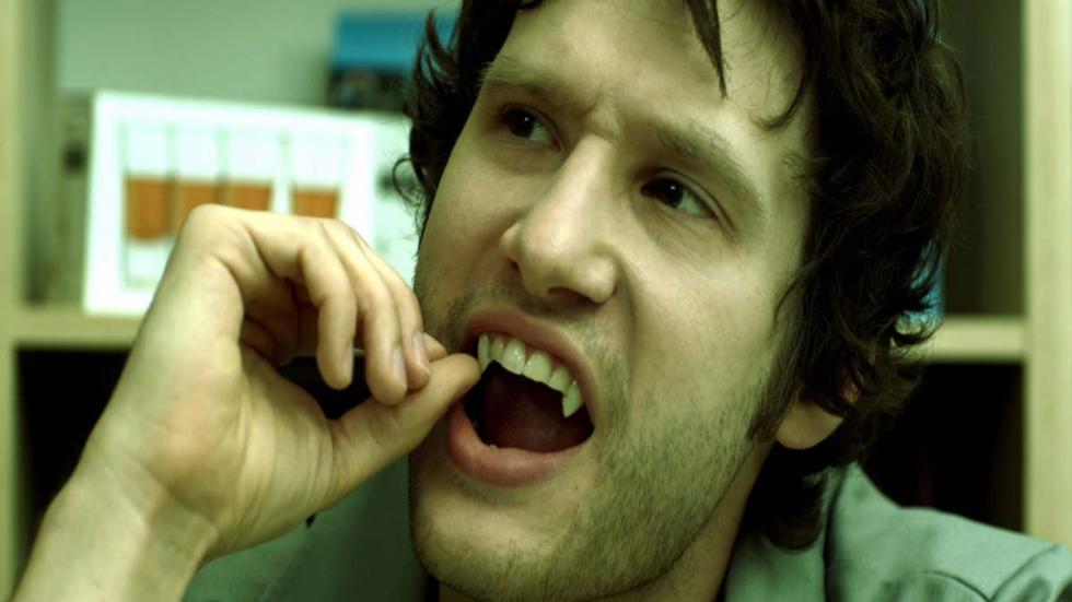 Third Shift man touches his vampire teeth