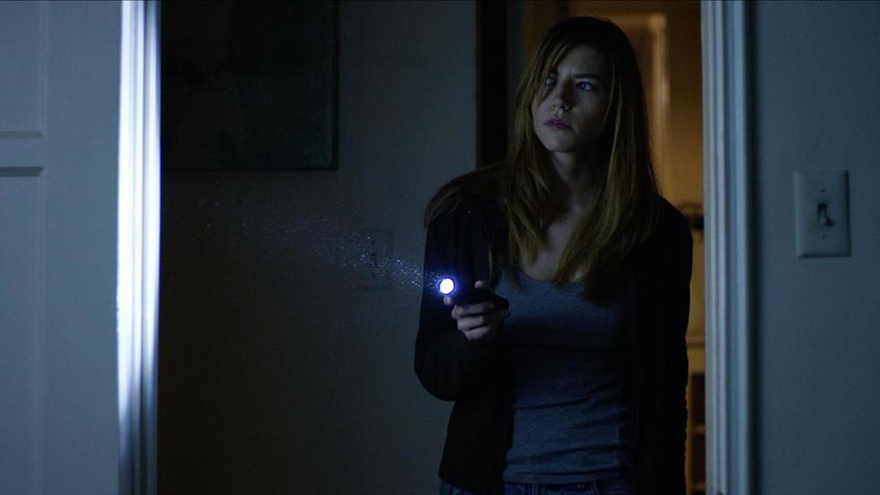 The Thing in the Apartment woman with a flashlight walks through the door