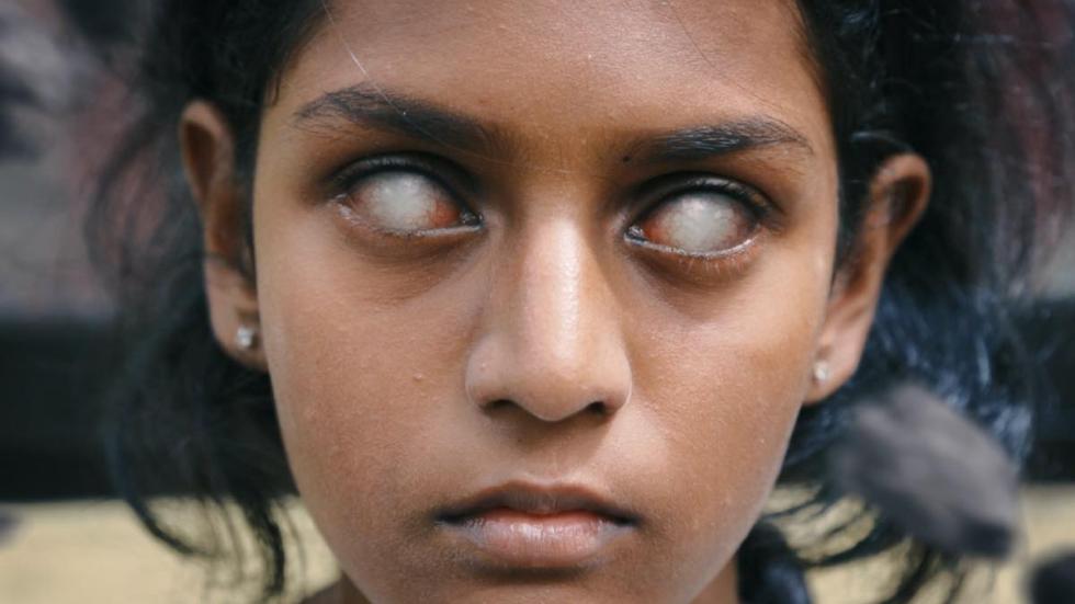 Vikaari film still young girl staring with white eyes