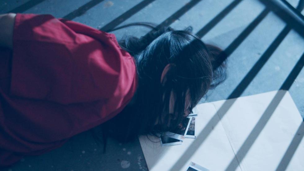 Warm Blood film still dead woman with polaroid photos near her head