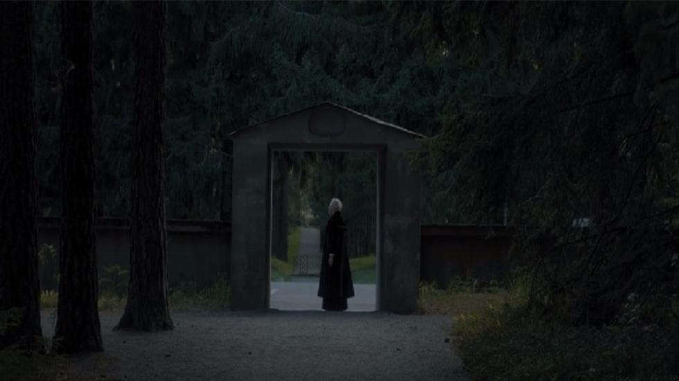 Woodland Cemetery film still person in black standing 