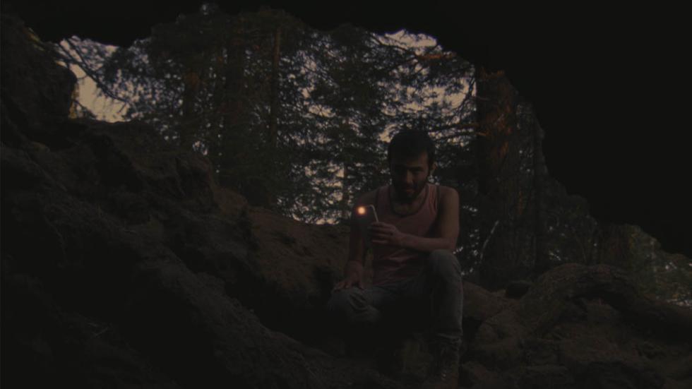 Wanna Go Camping? film still man looking in cave with his flashlight