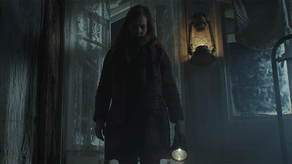 Whisper film still woman with a flashlight enters house