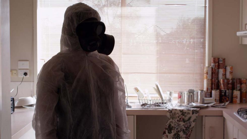 Zero woman in a gas mask and plastic coveralls